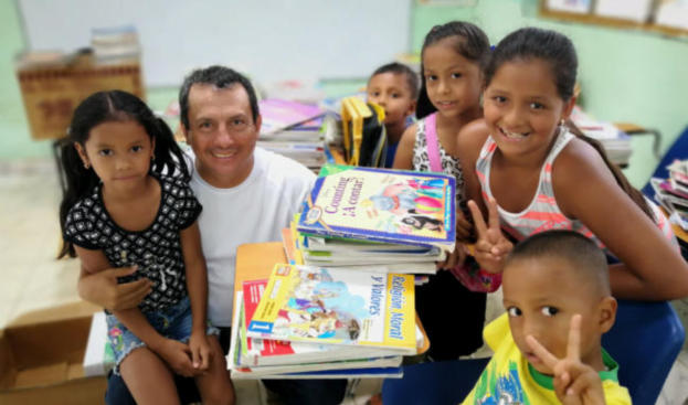 Mamomi Arriba students holding textbooks