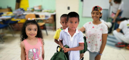 Niños mostrando sus nuevas mochilas